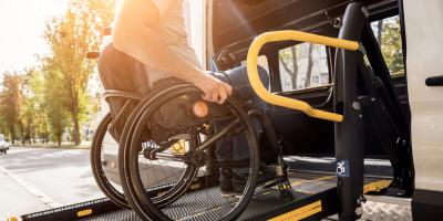 A man in a wheelchair on a lift of a vehicle