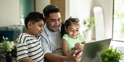 Father with his kids using laptop and mobile phone